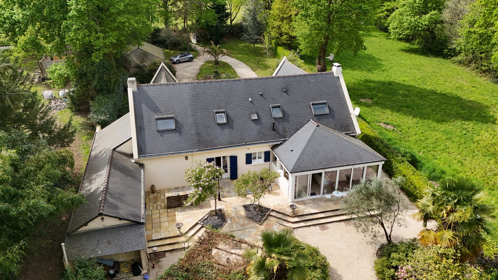 Vue aérienne de face d'une maison avec volets bleus et son jardin près de Nantes